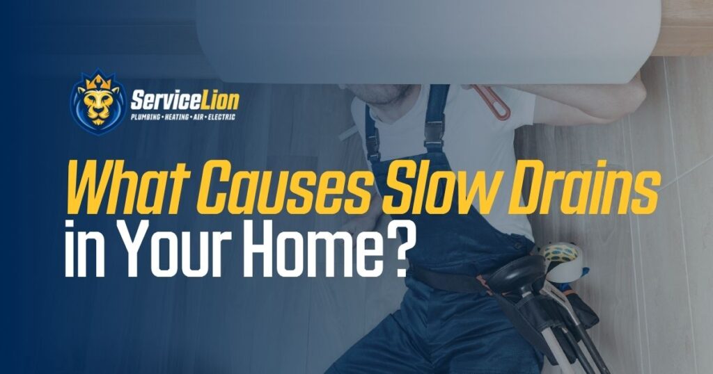 A plumber in overalls works under a sink with tools beside him; text reads, "What Causes Slow Drains in Your Home Plumbing?" with Service Lion branding.