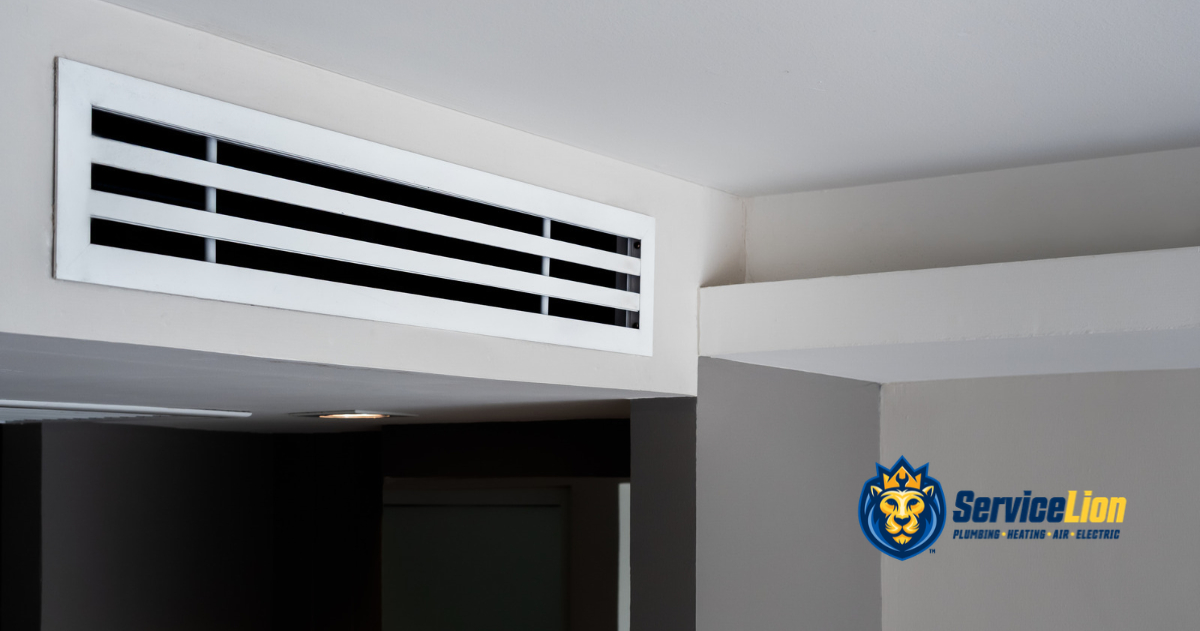 White HVAC air vent mounted on a ceiling corner, shown during air conditioning troubleshooting with the ServiceLion company logo in the lower right.
