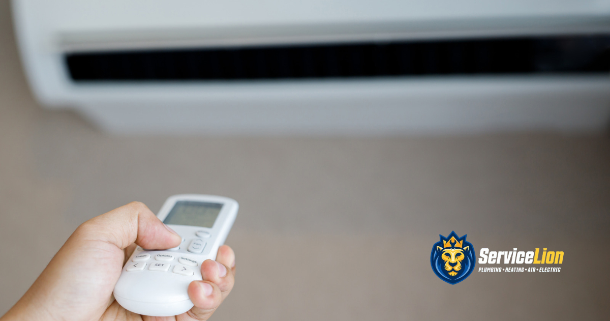 A hand holds a remote control pointed toward a wall-mounted air conditioner during troubleshooting.